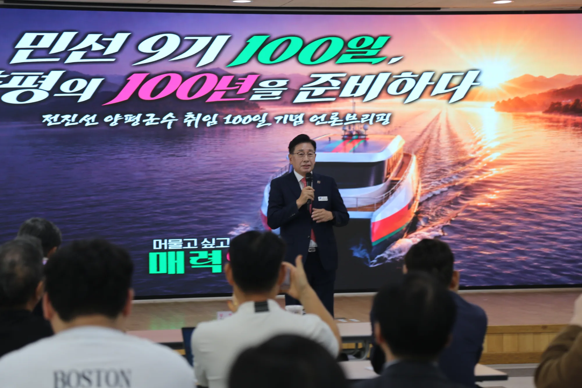 전진선 양평군수가 12일 취임 100일 기념 언론브리핑에서 양평의 미래 100년을 위한 군정 구상을 설명하고 있다. 행사장 화면에는 남한강 환경교육선 이미지가 띄워져 있다.